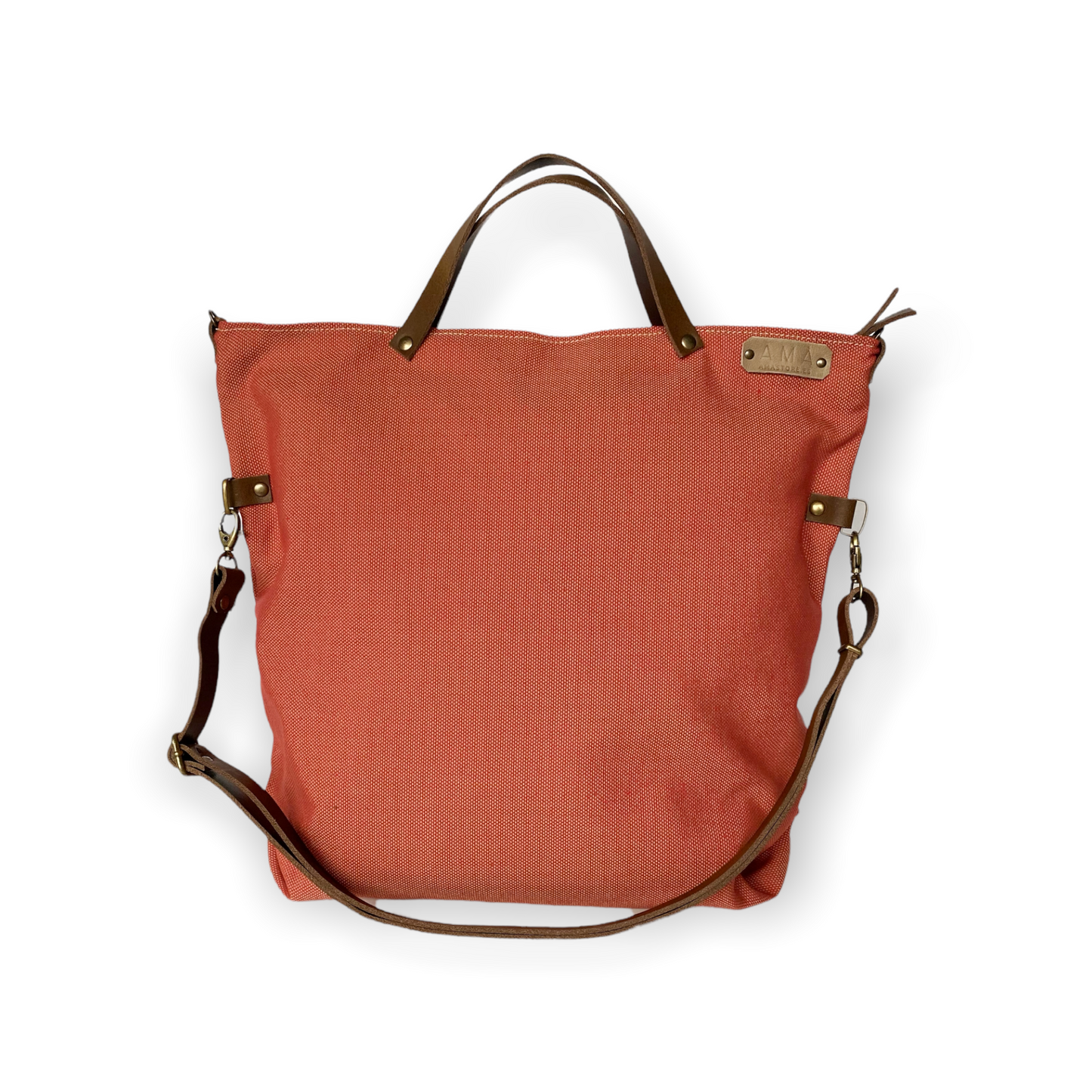 Bolso hecho a mano de loneta color teja antimanchas con forro y bolsillo interior. Un modelo super cómodo y funcional porque lo puedes llevar de mano, tipo bandolera o colgado al hombro. Las asas son de cuero regulable color marrón con mosquetones que puedes ponerlo a 2 alturas según la capacidad que necesites del bolso. Cierre con cremallera.