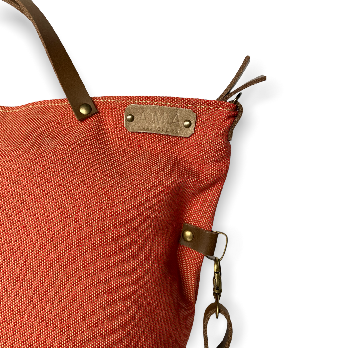 Bolso hecho a mano de loneta color teja antimanchas con forro y bolsillo interior. Un modelo super cómodo y funcional porque lo puedes llevar de mano, tipo bandolera o colgado al hombro. Las asas son de cuero regulable color marrón con mosquetones que puedes ponerlo a 2 alturas según la capacidad que necesites del bolso. Cierre con cremallera.