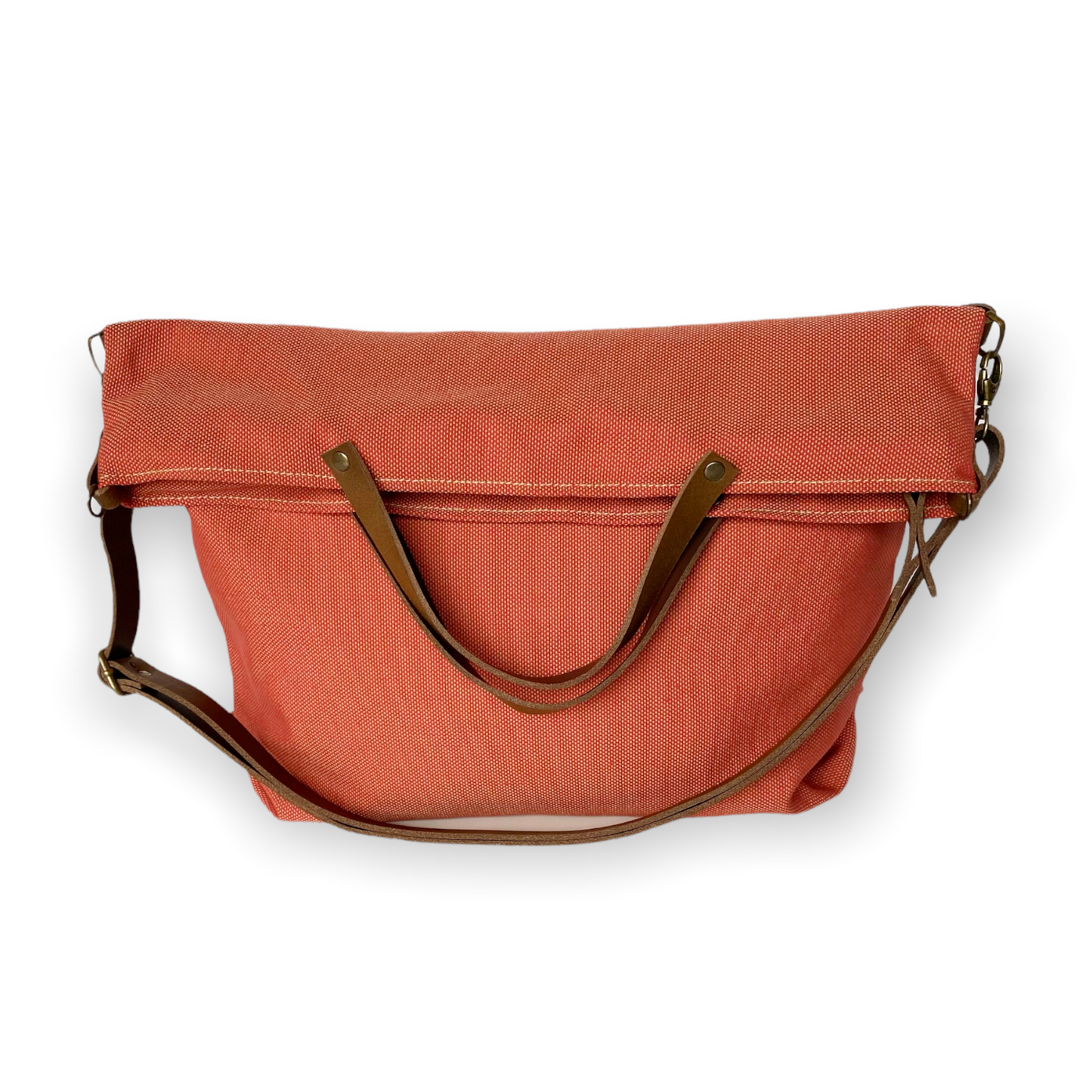Bolso hecho a mano de loneta color teja antimanchas con forro y bolsillo interior. Un modelo super cómodo y funcional porque lo puedes llevar de mano, tipo bandolera o colgado al hombro. Las asas son de cuero regulable color marrón con mosquetones que puedes ponerlo a 2 alturas según la capacidad que necesites del bolso. Cierre con cremallera.