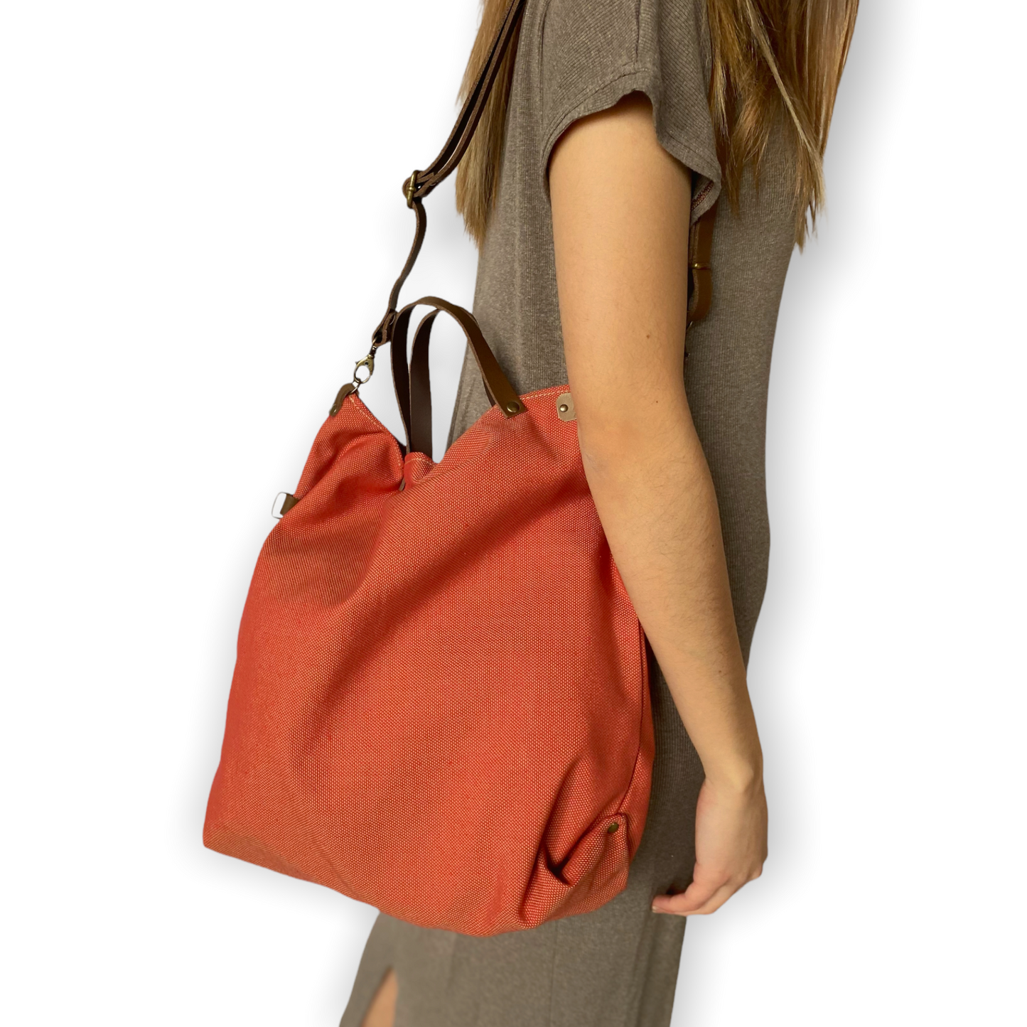 Bolso hecho a mano de loneta color teja antimanchas con forro y bolsillo interior. Un modelo super cómodo y funcional porque lo puedes llevar de mano, tipo bandolera o colgado al hombro. Las asas son de cuero regulable color marrón con mosquetones que puedes ponerlo a 2 alturas según la capacidad que necesites del bolso. Cierre con cremallera.