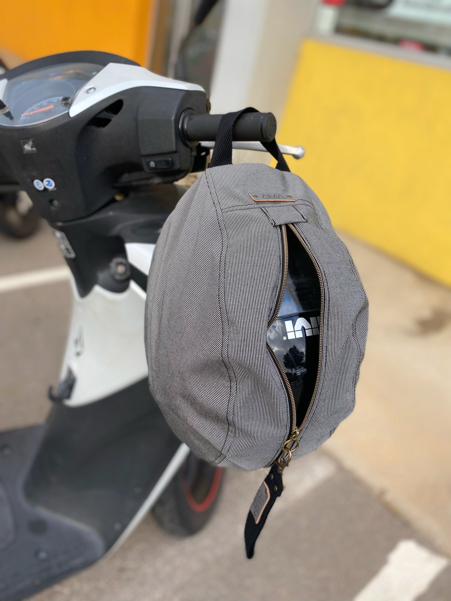 Mochila para casco gris impermable, realizada a mano en Barcelona en nuestro taller de retorno social. Capacidad para el casco de moto, casco de bici.. refuerzo acolchado en la espalda para más comodidad y protección.