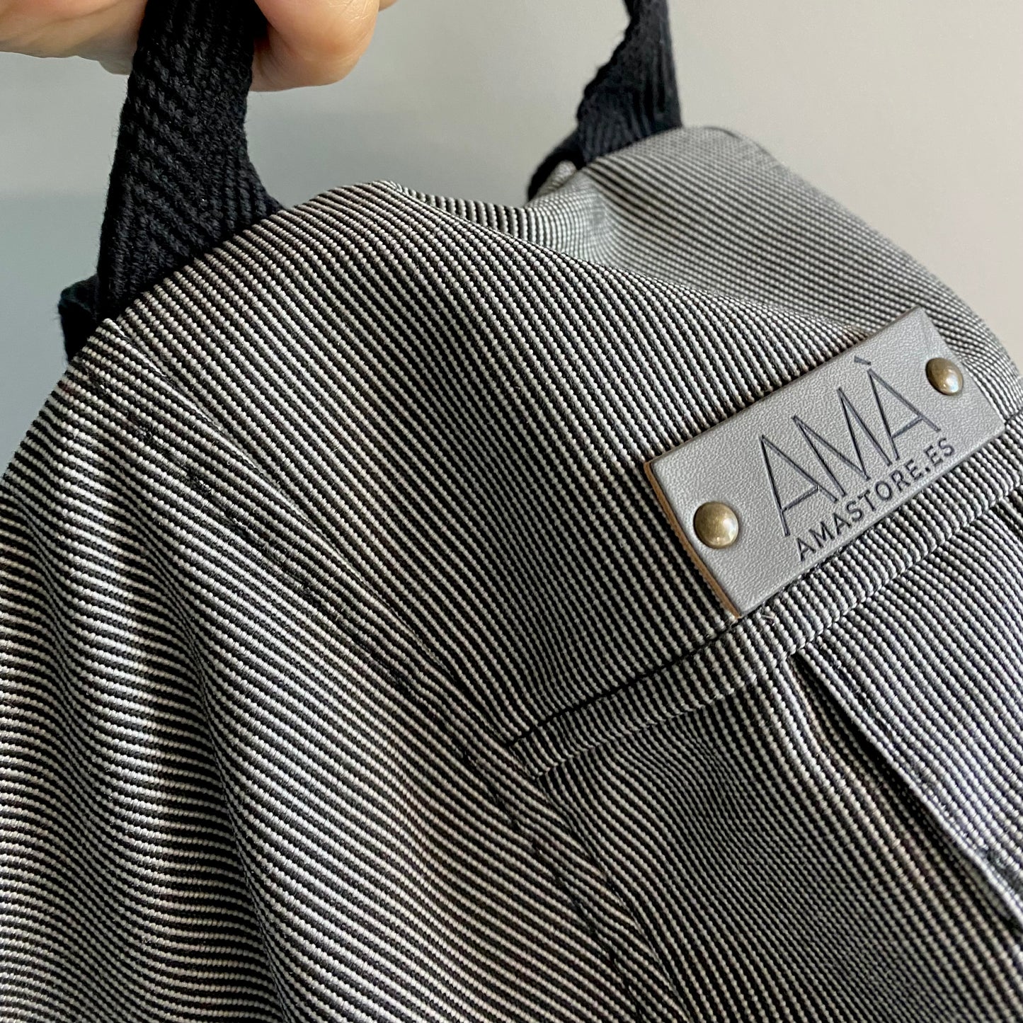 Mochila para casco gris impermable, realizada a mano en Barcelona en nuestro taller de retorno social. Capacidad para el casco de moto, casco de bici.. refuerzo acolchado en la espalda para más comodidad y protección.