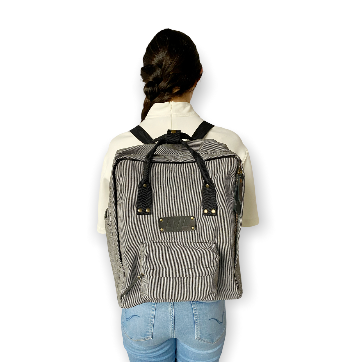 La mochila Alexa está hecha con tejido impermeable de rayas muy finas negras y blancas y con dos cintas negras en cinta de algodón regulables. En la parte superior tiene dos asas con un botón para proteger mejor su contenido. También tiene un bolsillo delantero donde podrás guardar las cosas para tenerlas más a mano y un bolsillo a cada lado para que puedas guardar el paraguas, la botella de agua…