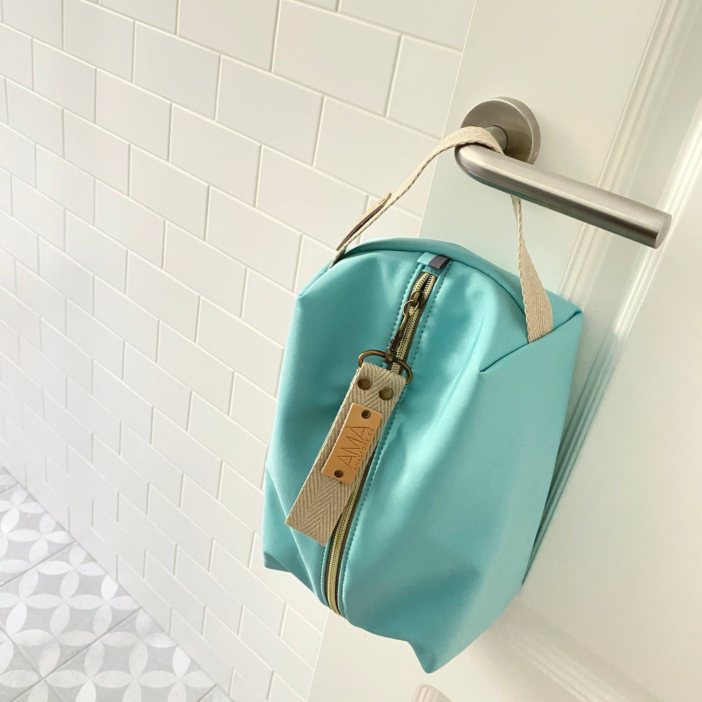 Neceser de tejido de neopreno color Aguamarina con una práctica asa de algodón color natural que te permitirá colgar el neceser del pomo de la puerta o cualquier colgador. Están realizados mano en Barcelona y disponen de forro repelente al agua y bolsillo interior. El tirador de la cremallera se convierte en un llavero extraible. Además puedes escoger personalizar tu neceser con 2 iniciales.
