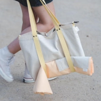 Este pareo facilitará tus viajes a la playa este verano. Está hecho de piqué de algodón que seca rápidamente, pero lo que diferencia a este pareo es su bolsillo de rayas amarillas y beiges que lleva un forro impermeable y velcro, así podrás guardar sin que se moje tu teléfono, las llaves y hasta el bañador mojado .