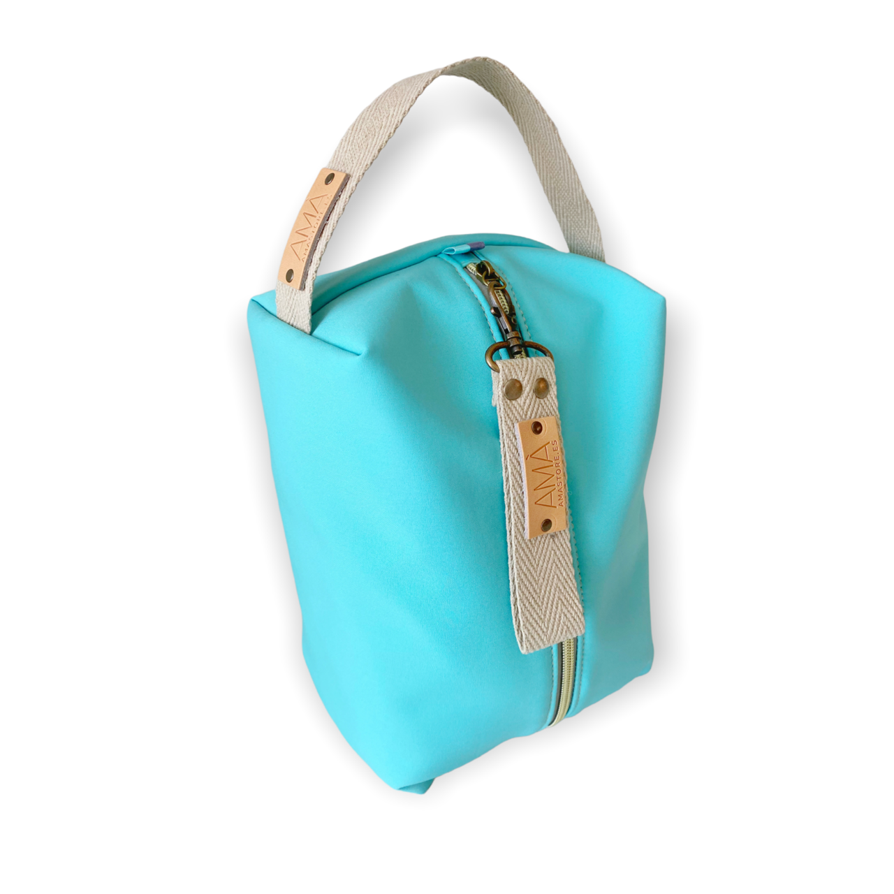 Neceser de tejido de neopreno color Aguamarina con una práctica asa de algodón color natural que te permitirá colgar el neceser del pomo de la puerta o cualquier colgador. Están realizados mano en Barcelona y disponen de forro repelente al agua y bolsillo interior. El tirador de la cremallera se convierte en un llavero extraible. Además puedes escoger personalizar tu neceser con 2 iniciales.