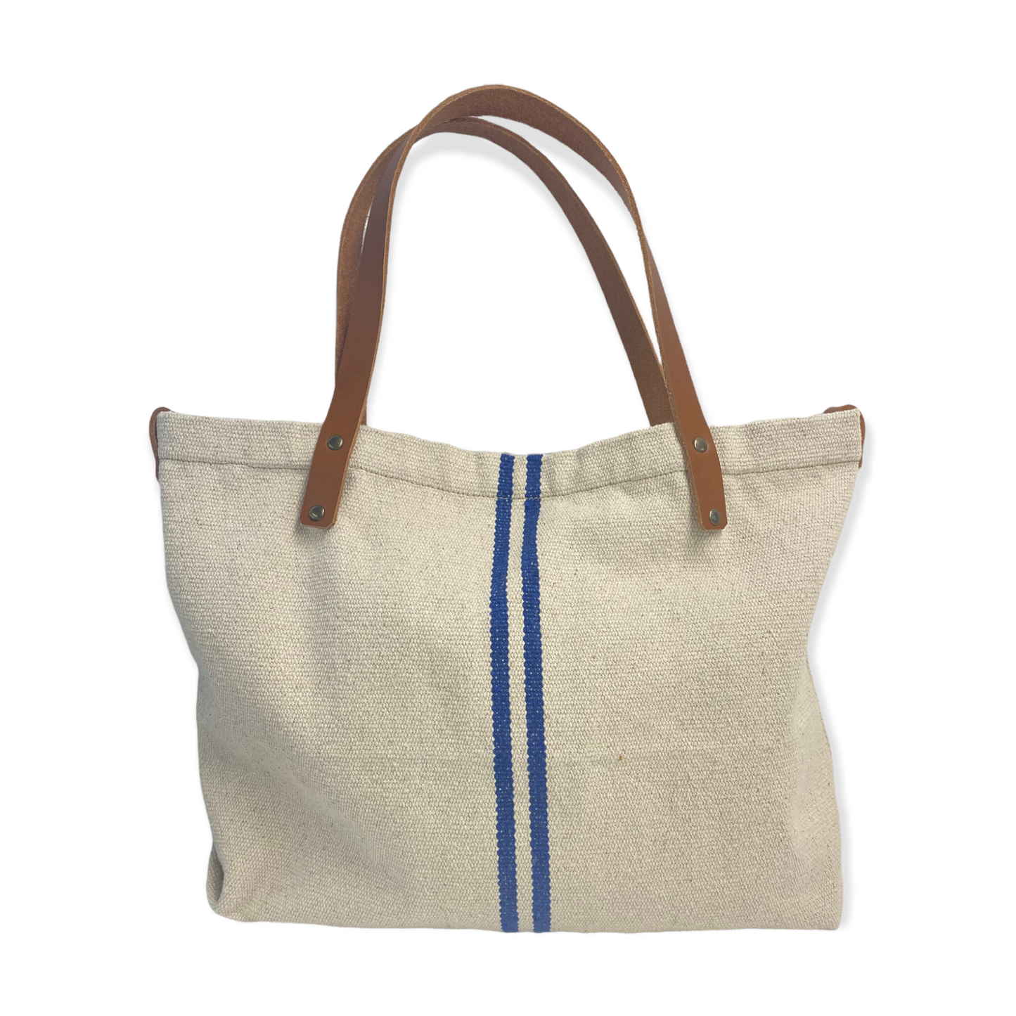 Tote Bag realizado a mano en Barcelona con loneta tipo saco con 2 rayas azules. Un modelo muy veraniego y atemporal, hace muchos años que usamos este tejido en alguno de nuestros bolsos porque nos vienen muchas ganas de vacaciones cada vez que lo hacemos :) Las asas son de cuero color teja y lleve un cierre de imán en el medio. Medidas: 42 x 33 cm