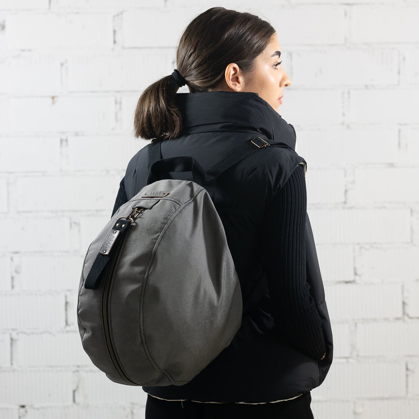 Mochila para casco gris impermable, realizada a mano en Barcelona en nuestro taller de retorno social. Capacidad para el casco de moto, casco de bici.. refuerzo acolchado en la espalda para más comodidad y protección.