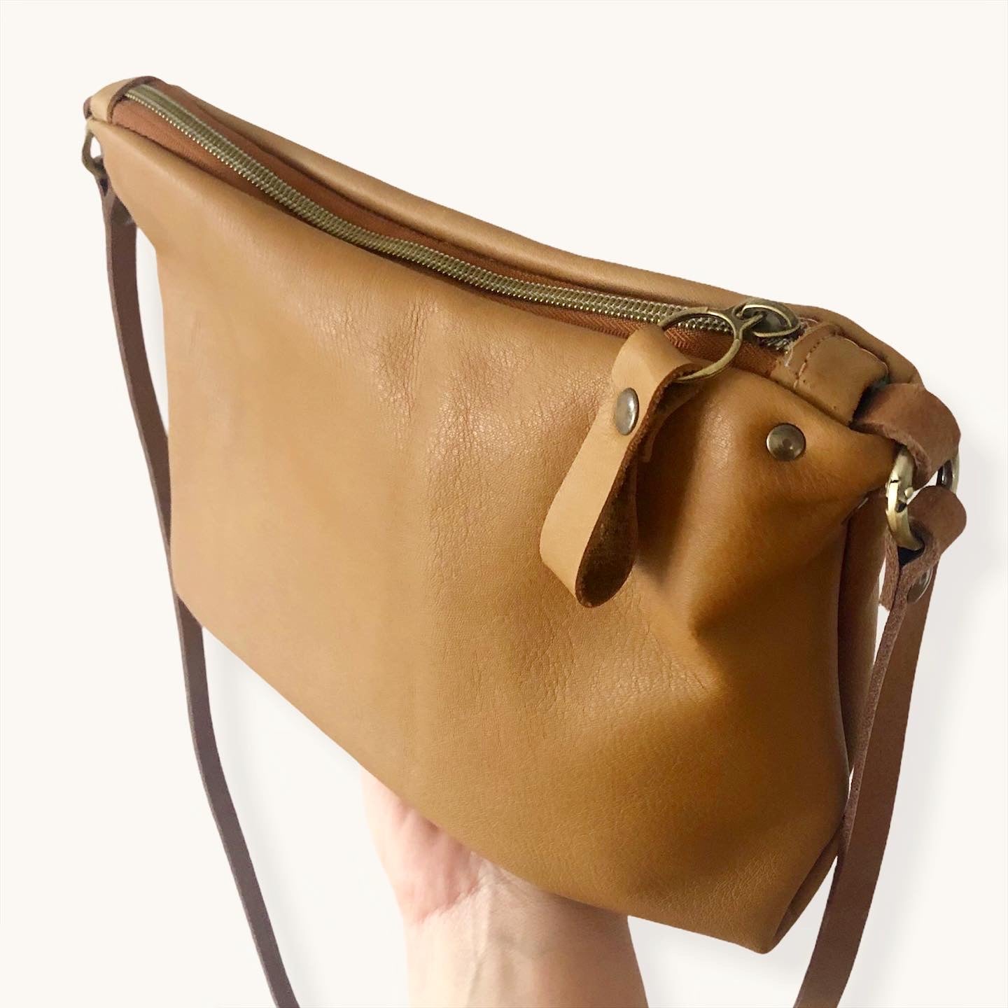 El Bolso bandolera Porto Covo es ideal para llevar lo imprescindible. Está realizado con piel muy suave de color Camel. Tira de cuero color marrón y además lleva una tira extra de algodón natural color beige para que puedas cambiarlo y darle un look diferente a tu bolso.