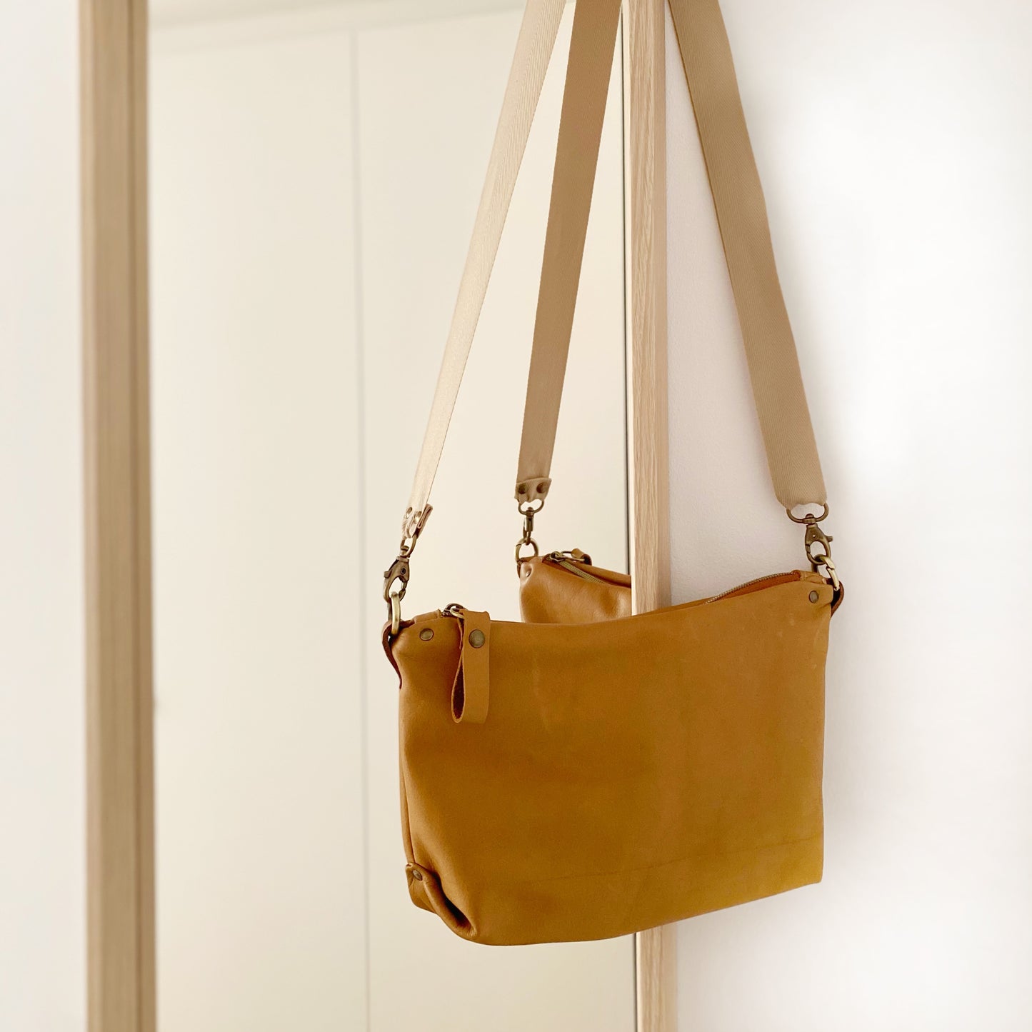 El Bolso bandolera Porto Covo es ideal para llevar lo imprescindible. Está realizado con piel muy suave de color Camel. Tira de cuero color marrón y además lleva una tira extra de algodón natural color beige para que puedas cambiarlo y darle un look diferente a tu bolso.