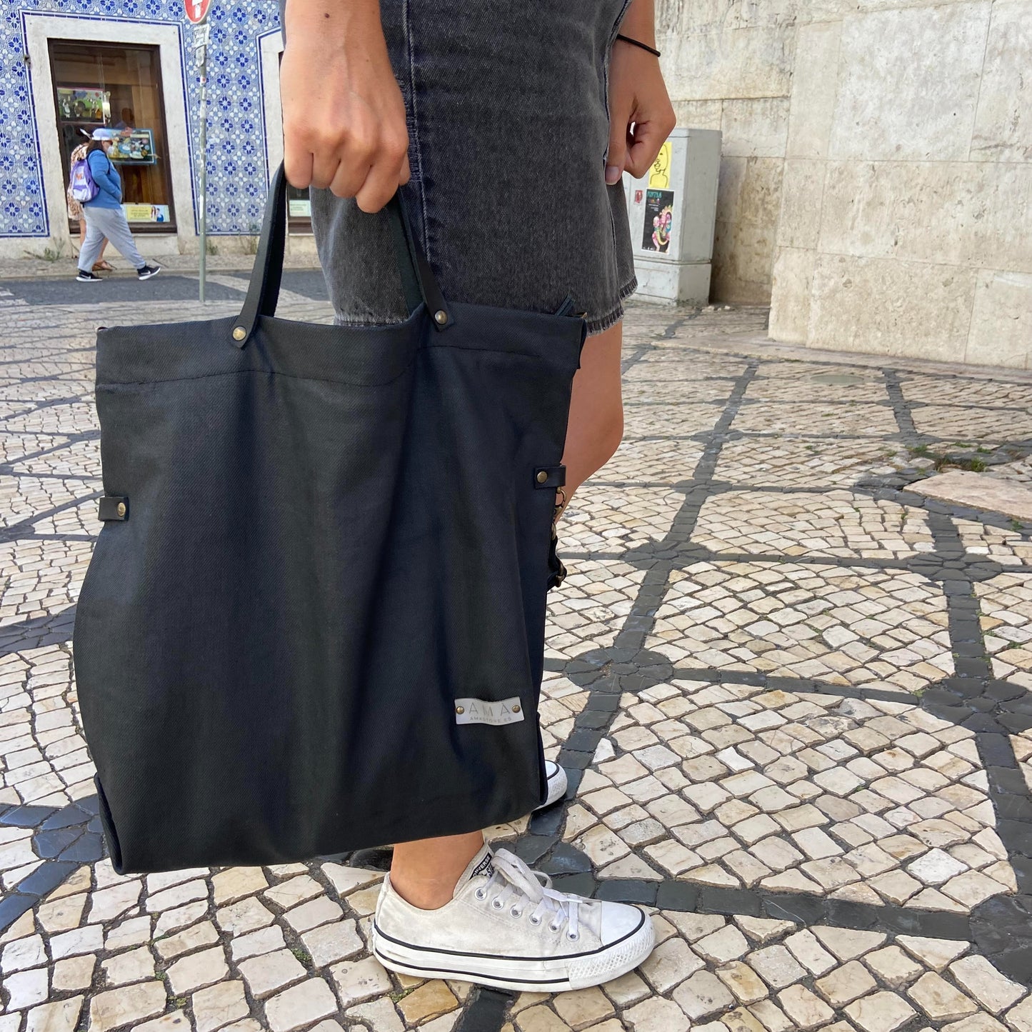 Bolso de tejido vaquero encerado color negro con forro y bolsillo interior. Un modelo super cómodo y funcional porque lo puedes llevar de mano, tipo bandolera o colgado al hombro. D Las asas son de cuero regulable negro con mosquetones que puedes ponerlo a 2 alturas según la capacidad que necesites del bolso. Cierre con cremallera Este bolso tiene 2 opciones bandolera o Tote bag. Lleva un llavero que se puede colgar dentro de regalo para tener siempre tus llaves a mano.