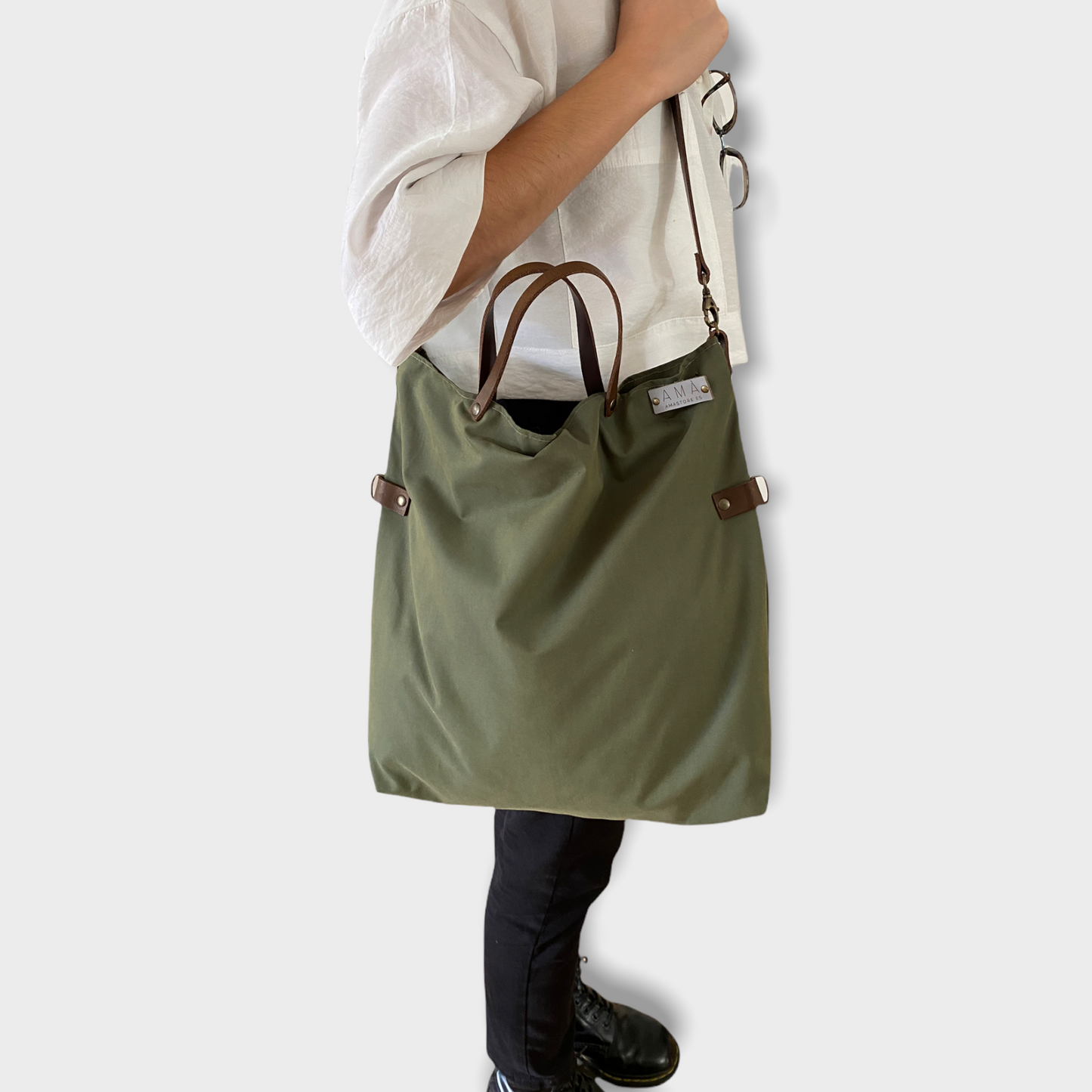 Bolso hecho a mano de tejido tipo loneta color verde militar con forro y bolsillo interior. Un modelo super cómodo y funcional porque lo puedes llevar de mano, tipo bandolera o colgado al hombro. Las asas son de cuero regulable color marrón con mosquetones que puedes ponerlo a 2 alturas según la capacidad que necesites del bolso. Cierre con cremallera. Este bolso tiene 2 opciones bandolera o Tote bag. Lleva un llavero que se puede colgar dentro de regalo para tener siempre tus llaves a mano.