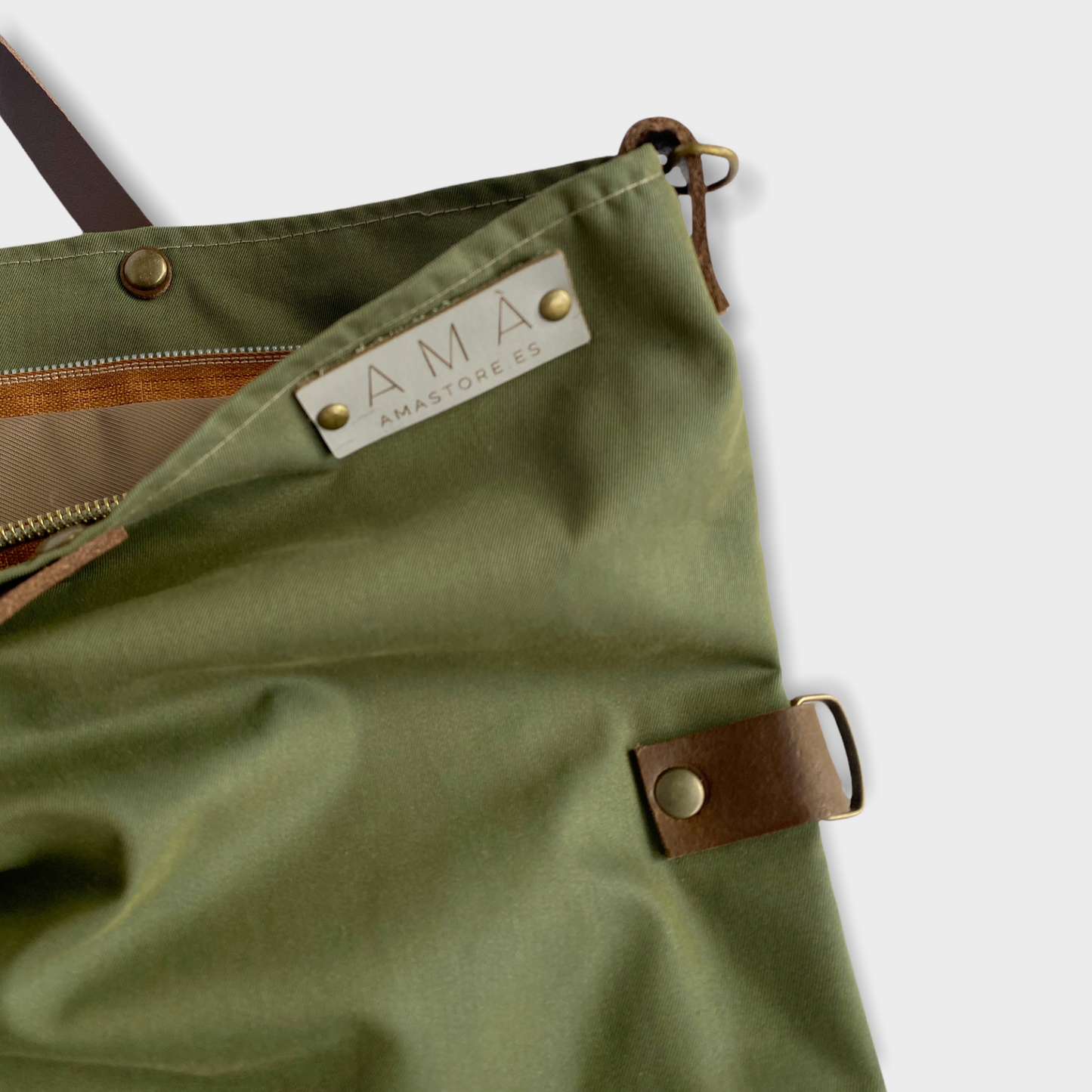 Bolso hecho a mano de tejido tipo loneta color verde militar con forro y bolsillo interior. Un modelo super cómodo y funcional porque lo puedes llevar de mano, tipo bandolera o colgado al hombro. Las asas son de cuero regulable color marrón con mosquetones que puedes ponerlo a 2 alturas según la capacidad que necesites del bolso. Cierre con cremallera. Este bolso tiene 2 opciones bandolera o Tote bag. Lleva un llavero que se puede colgar dentro de regalo para tener siempre tus llaves a mano.