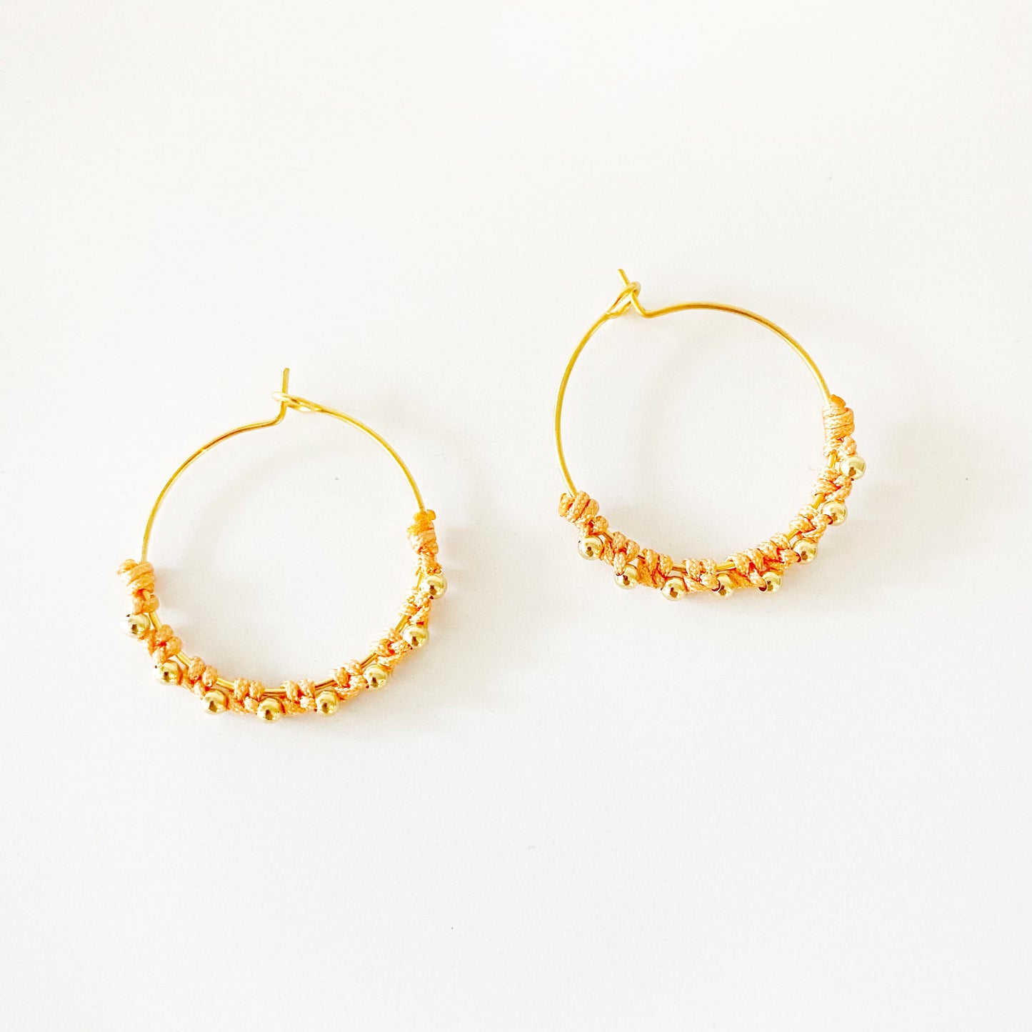 Pendientes realizados a mano con arito de 25mm con baño de Plata de Ley o de Oro de 2 micras y bolitas con nudos de macramé de diferentes colores.