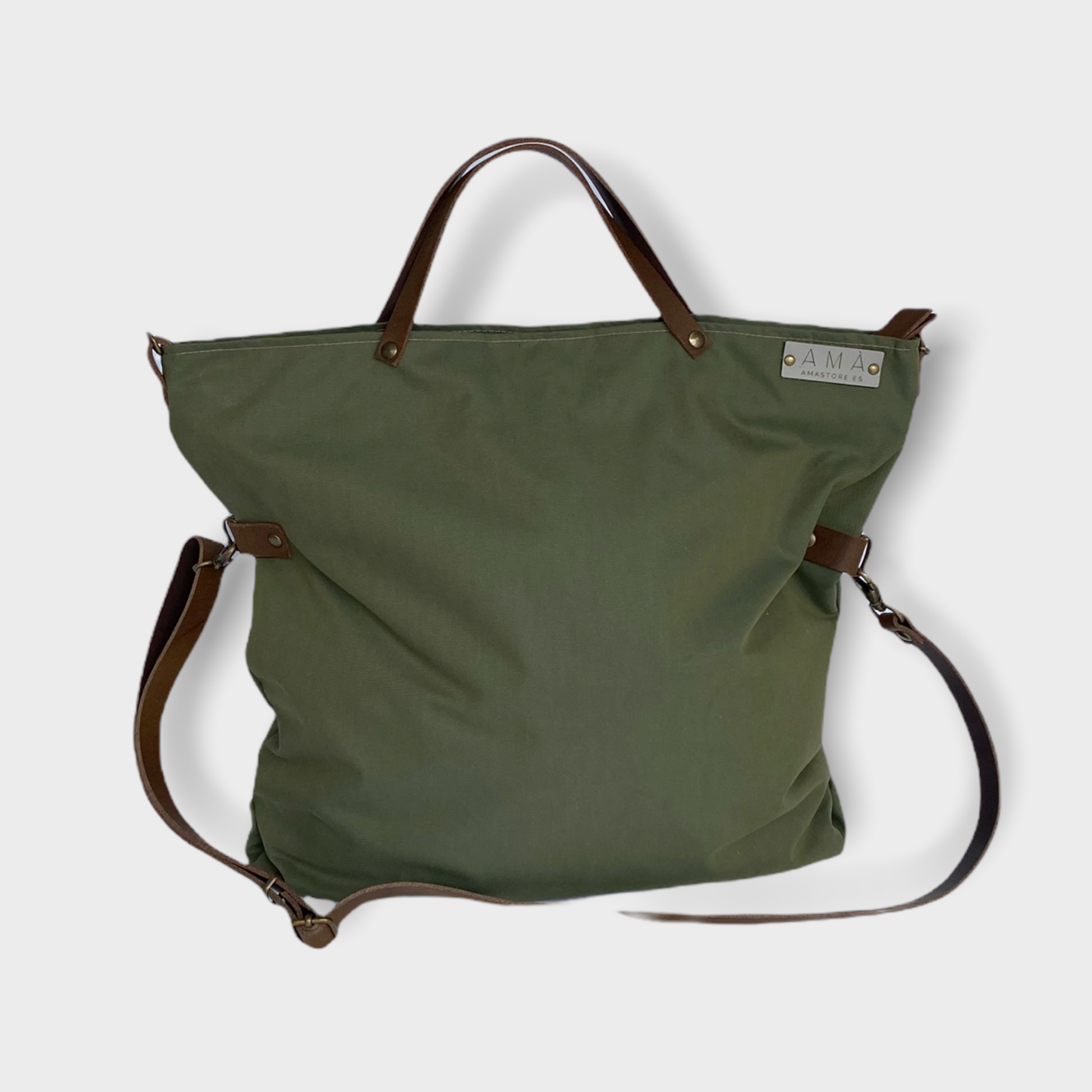 Bolso hecho a mano de tejido tipo loneta color verde militar con forro y bolsillo  interior. Un modelo super cómodo y funcional porque lo puedes llevar de mano, tipo bandolera o colgado al hombro.   Las asas son de cuero regulable color marrón con mosquetones que puedes ponerlo a 2 alturas según la capacidad que necesites del bolso. Cierre con cremallera.  Este bolso tiene 2 opciones bandolera o Tote bag. Lleva un llavero que se puede colgar dentro de regalo para tener siempre tus llaves a mano.