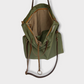 Bolso hecho a mano de tejido tipo loneta color verde militar con forro y bolsillo  interior. Un modelo super cómodo y funcional porque lo puedes llevar de mano, tipo bandolera o colgado al hombro.   Las asas son de cuero regulable color marrón con mosquetones que puedes ponerlo a 2 alturas según la capacidad que necesites del bolso. Cierre con cremallera.  Este bolso tiene 2 opciones bandolera o Tote bag. Lleva un llavero que se puede colgar dentro de regalo para tener siempre tus llaves a mano.